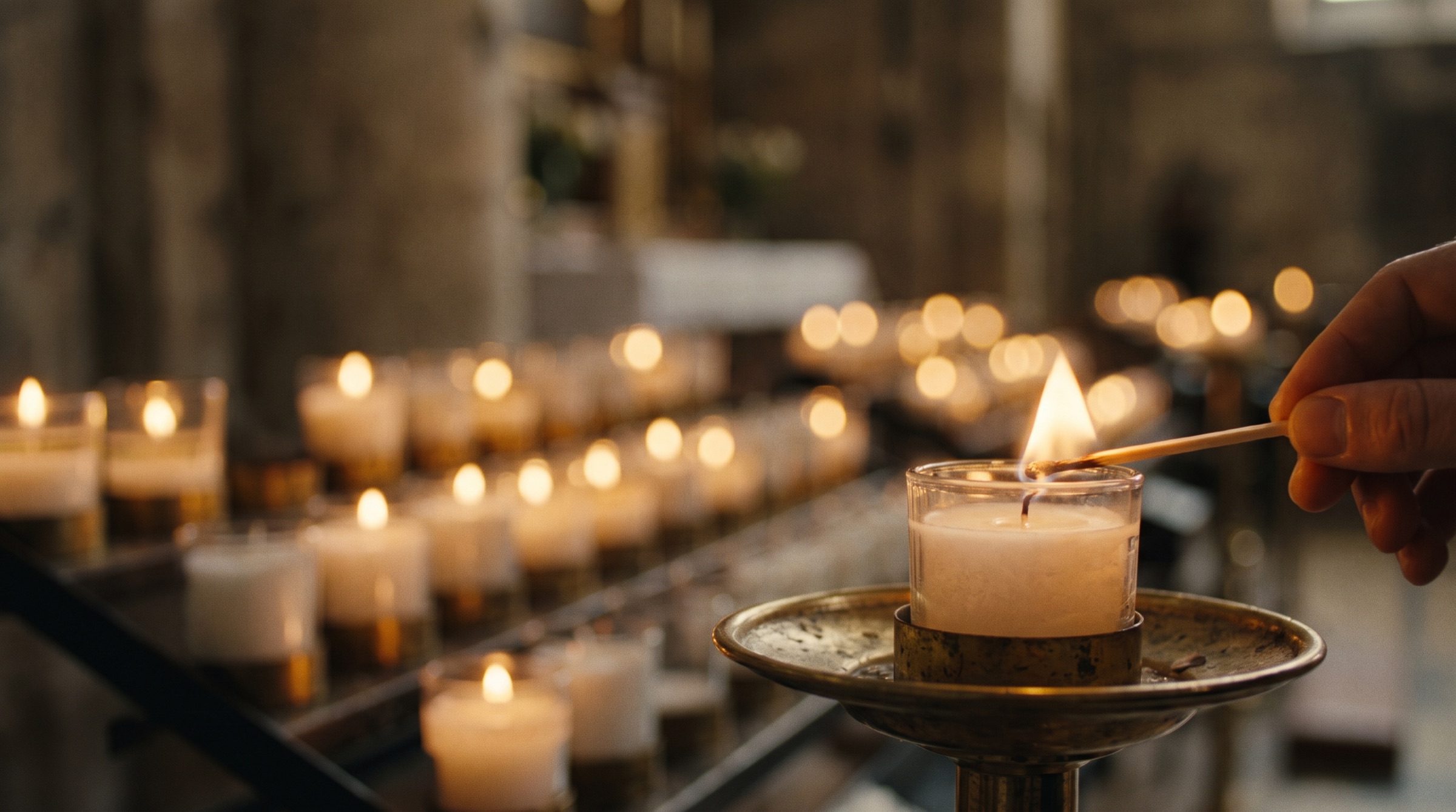Votive candles glowing in a dim stone church